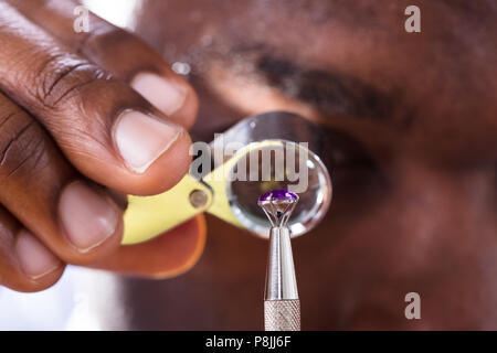 Close-up Of Jeweler Examining Diamond Through Loupe Stock Photo