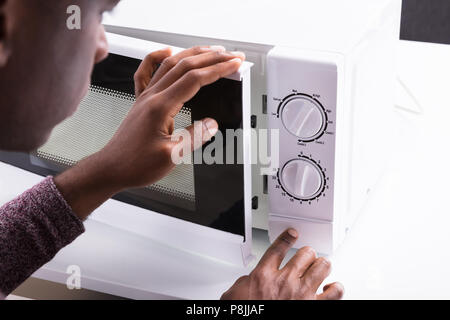Close-up of pressing timer button on electric stove. Action. Finger ...