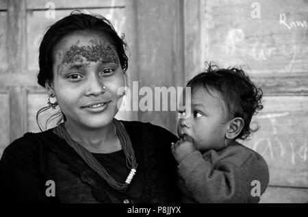 A giant RICE TIKA beautifies this young mother with child in KHANDBARI on route to MAKALU - NEPAL Stock Photo