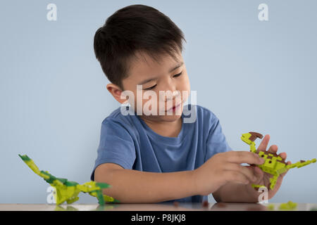 Portrait of cute asian boy playing with colorful plastic toy bricks at the table. Stock Photo