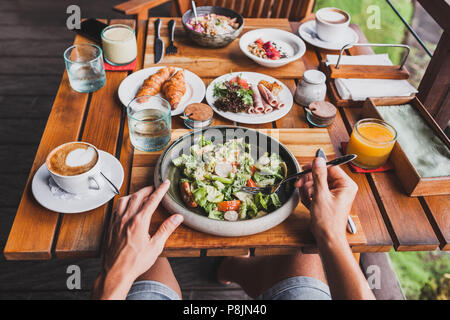View from above on table with fresh breakfast. Man hands holding fork and knife Stock Photo
