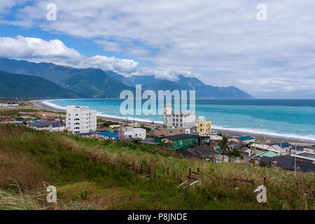 Chisingtan Scenic Area, bay with azure waters oceanside view, Central Mountain Range with partly cloudy blue sky in the background, Hualien, Taiwan Stock Photo