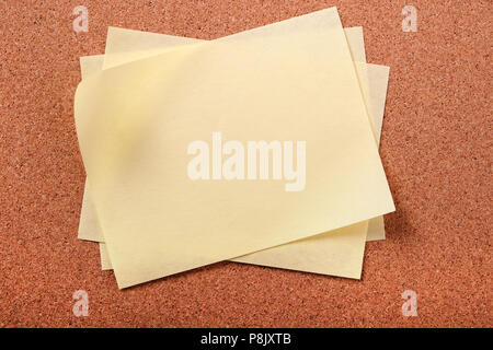 Pile several untidy yellow post notes cork notice board Stock Photo