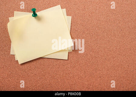 Several yellow sticky post notes pinned pushpin cork board Stock Photo