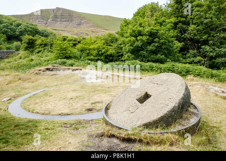 A millstone at the Crushing Circle near Castleton, Derbyshire, England, UK. Mam Tor is in the distance. Stock Photo