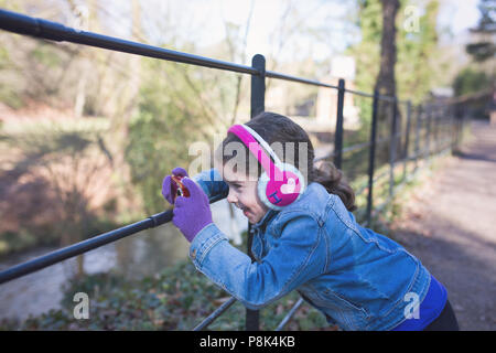 Girl taking a photo on a family walk by a river in autumn. Stock Photo