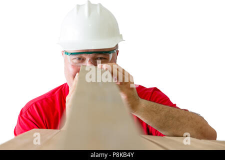 Cheerful worker wearing helmet and safety glasses inspecting quality of wooden plank isolated against white background Stock Photo