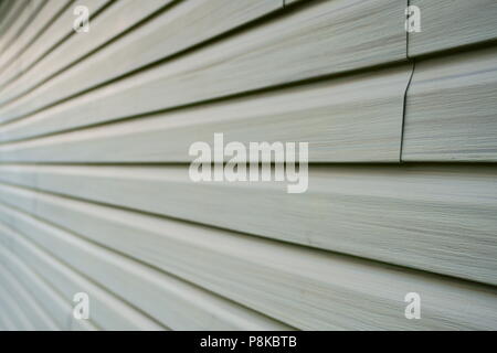Tiles of vinyle covering an exterior wall of a residential home in North America in order to isolate the house from the cold winter season. Stock Photo