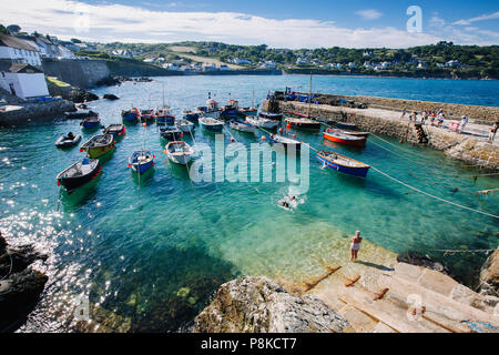 A picturesque view of traditional Cornish fishing boats floating in the harbour of the popular Cornish fishing village of Coverack in Cornwall, UK Stock Photo