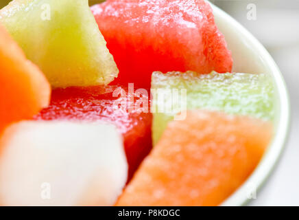 close up macro shot of four diffrent types of melon cut into parts colors of red white orange and lime , seletcive focus background to ad copy space Stock Photo
