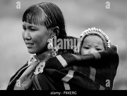 WOMAN and CHILD in DOLPO BLANKET and silver clasp at a Tibetan Buddhist FESTIVAL in DO TARAP VALLEY - DOLPO, NEPAL Stock Photo