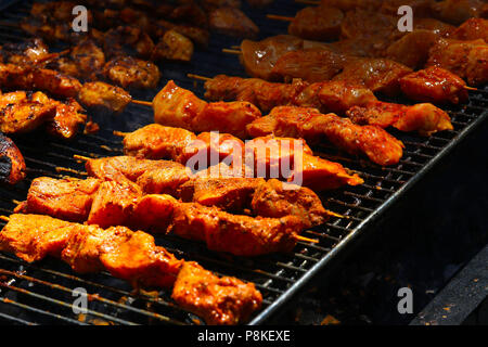 Chicken kebabs cooking on a grill Stock Photo