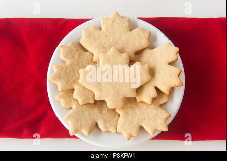 Round white plate filled with maple leaf shaped sugar cookies Stock Photo