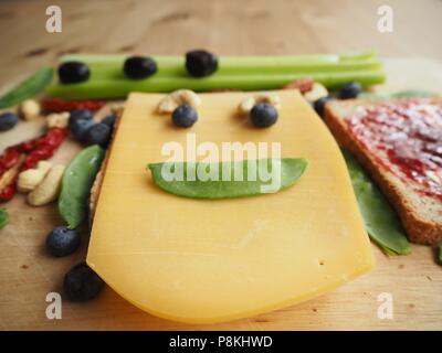 Cheese toast with dried tomatoes, black olives and cashew nuts on a wooden tabl Stock Photo