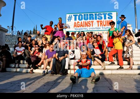 Athens, Greece. 12th July, 2018. People seen sitting down while some hold a banner.Tourist have taken part in the demonstration named, Tourist against Trump in the capital city of Greece to show their anger toward the US president's policies. Credit: Helen Paroglou/SOPA Images/ZUMA Wire/Alamy Live News Stock Photo