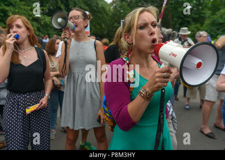 London, UK. 12th July 2018. Hundreds of campaigners with drums, whistles, megaphones, pots and pans, recordings of the cries of migrant children and some very loud shouting attempt to make their feelings about President Trump clear to him close to the US Ambassador's residence in Regent's Park London where he flew in briefly before flying out for dinner. The protesters aimed to keep up the noise all night as he was flying back to sleep there. A large security presence with a high fence kept them at some distance from the residence. Peter Marshall/Alamy Live News Stock Photo