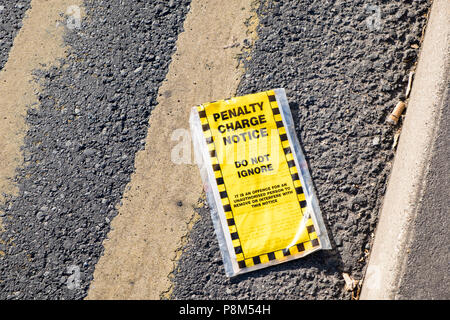 Discarded penalty charge notice. Parking fine removed from vehicle and thrown on a road with double yellow lines, Nottinghamshire, England, UK Stock Photo
