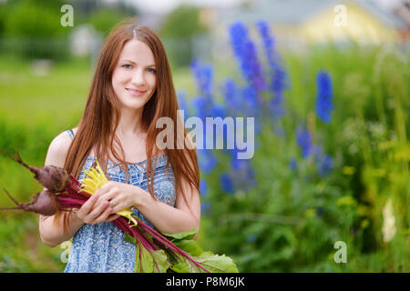 Young beautiful woman holding fresh organic vegetables Stock Photo