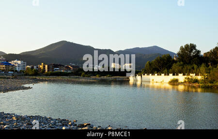 View of private houses located on the shore of a small river in the foothills of the North Caucasus. Stock Photo