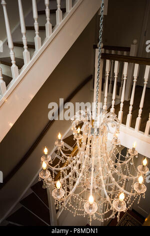 Beautiful staircase in victorian style with crystal chandelier and decorative railing Stock Photo