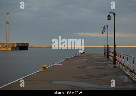 harbour pier with black lanterns in evening light in summer cloudy day Stock Photo