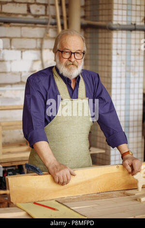 grandpa wearing glasses leaning on the wood plank Stock Photo