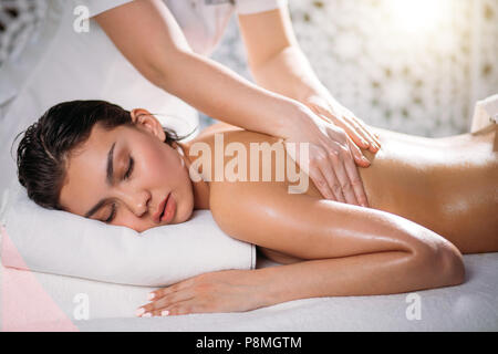 masseur's hands rubbing nice female client down in the spa salon. free time Stock Photo