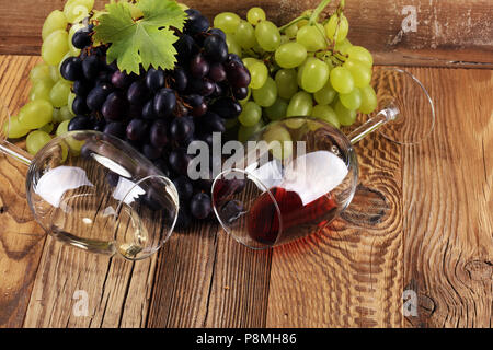 Red Wine and white wine with grapes and glasses on rustic background Stock Photo