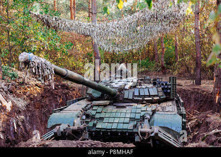 The tank from the hidden position is disguised in the trench Stock Photo