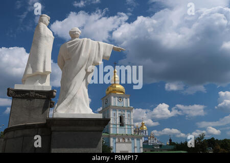 View of the statues of Saint Cyril and Methodius on St Michael Square, with the entrance to St Michael golden domed monastery in the city of Kyiv or Kiev capital of Ukraine Stock Photo