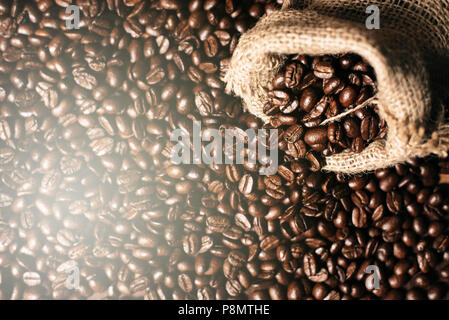full frame image of fresh dark roasted coffee beans with gunny burlap sack. can be use as background,wallpaper and backdrop Stock Photo