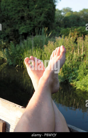 Feet up and relaxing by the river on a late summer evening in southern England. 2018. Stock Photo
