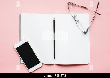 Smart phone, pencil and glasses on open notebook Stock Photo
