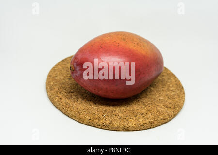 red mango fruit on cork isolated on white background Stock Photo