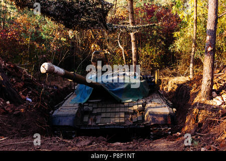 The tank from the hidden position is disguised in the trench Stock Photo