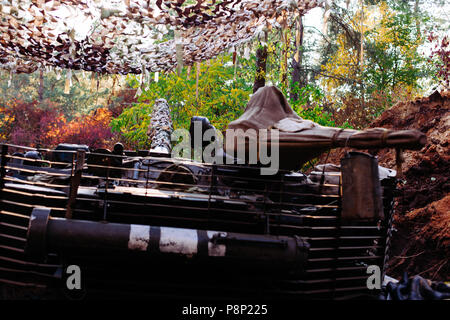 The tank from the hidden position is disguised in the trench Stock Photo