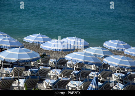 Blue and white parasols on Nice beach Stock Photo