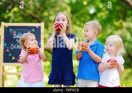 Four adorable little kids feeling very excited about going back to school Stock Photo