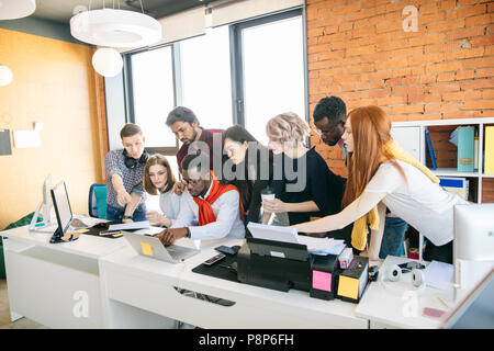 African guy watching film with his friends in the loft room. Stock Photo