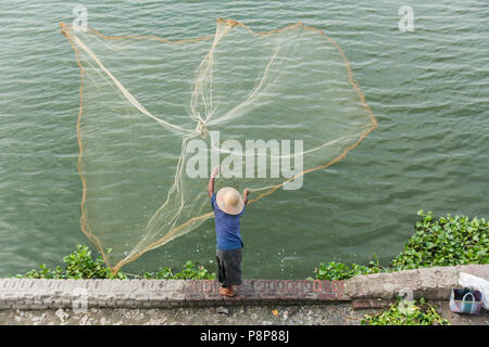 Fisherman casting net at U Bein Bridge, Mandalay, Myanmar (Burma) Stock Photo