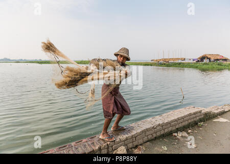 Fisherman casting net at U Bein Bridge, Mandalay, Myanmar (Burma) Stock Photo