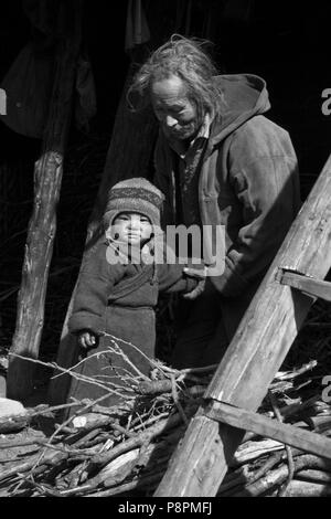 GRANDFATHER with CHILD in the village of SAMDO on the AROUND MANASLU TREK - NUPRI REGION, NEPAL Stock Photo