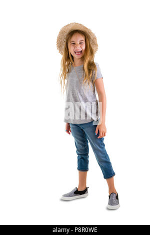 Happy pretty little blond girl with long tousled blond hair wearing trendy jeans and straw hat for summer laughing at the camera in a full length port Stock Photo