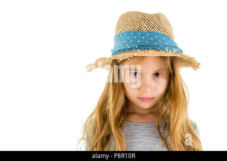Solemn thought little 6 year old girl wearing a trendy straw sunhat looking intently at the camera isolated on white Stock Photo