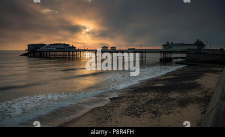 Cromer pier with clouds at sunrise, Norfolk, England Stock Photo