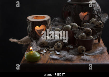 Chicken quail eggs, candles and tree branches, feathers and decor for Easter. Copy space Stock Photo