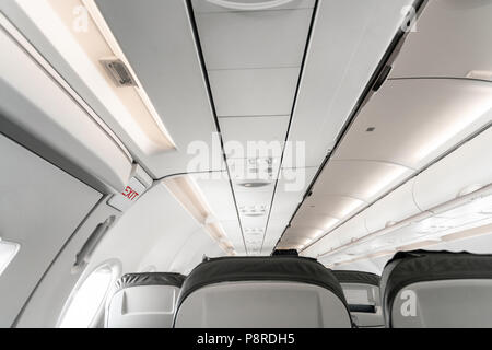 Emergency exit on an aircraft, view from inside of the plane. Empty airplane seats in the cabin. Modern Transportation concept. Aircraft long-distance international flight Stock Photo