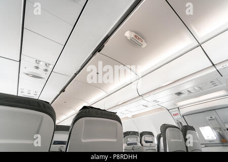 Emergency exit on an aircraft, view from inside of the plane. Empty airplane seats in the cabin. Modern Transportation concept. Aircraft long-distance international flight Stock Photo