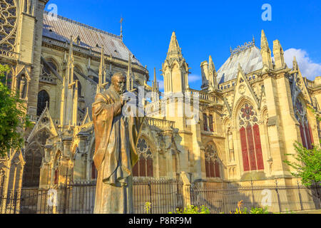 Details of Pope John Paul II statue on side of church Notre Dame of Paris, France. Gothic architecture of Cathedral of Paris, Ile de la cite. Beautiful sunny day in the blue sky. Stock Photo