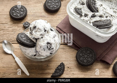 Ice cream with chocolate and cream sandwich cookies. Cookies and cream homemade ice cream dessert on dark wooden background. Stock Photo